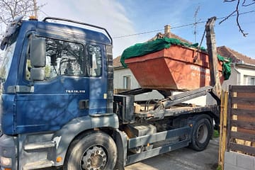Konténer hulladék számára, teherautóról lerakása konténer rendeléskor, piros színű konténer oldalán rá van írva bau-sitt.hu és a cég telefonszáma 06706285332